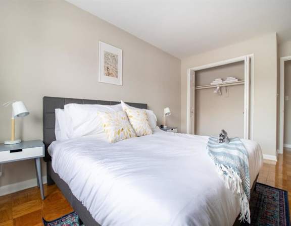 A bedroom with a bed, nightstand, and a rug.
