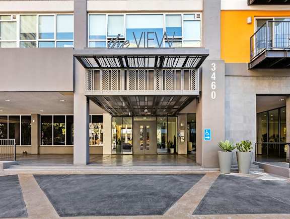 A large building with a pool and lounge chairs. at The View, Los Angeles, California
