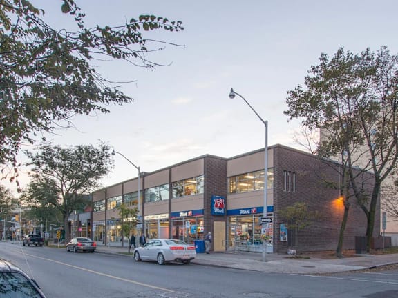 A street view of a building with cars parked in front of it.
