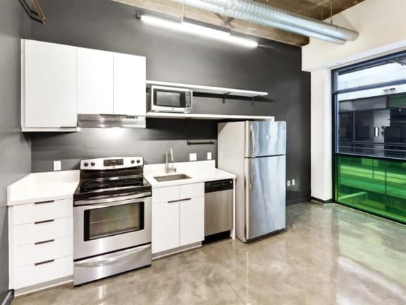 a kitchen with white cabinets and stainless steel appliances