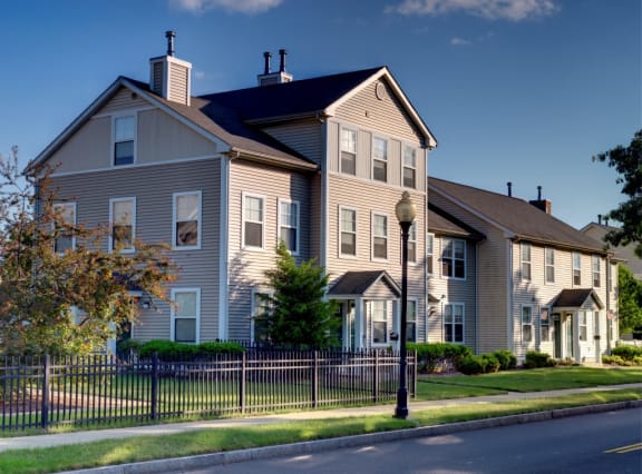 a house with a fence in front of a street