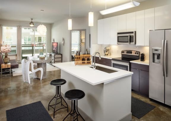 a kitchen with a large center island next to a stove top oven