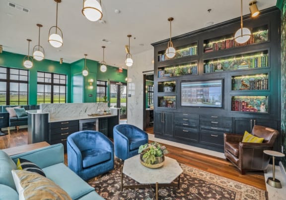 a living room with blue furniture and a bar and green walls