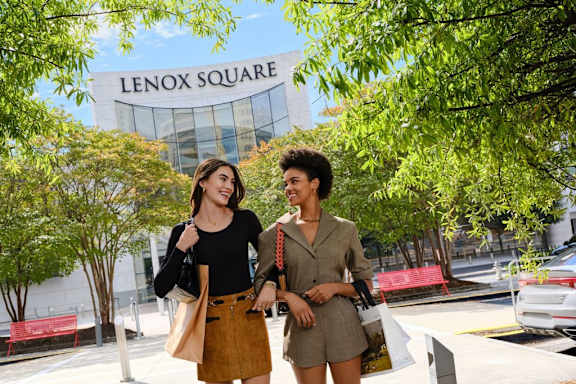 Two people standing in front of Lenox Square shopping center.