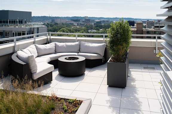 A patio with a white couch and a black table.