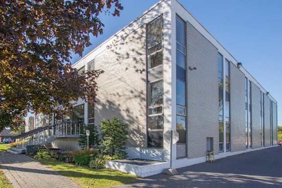 A modern building with a grey facade and large windows.