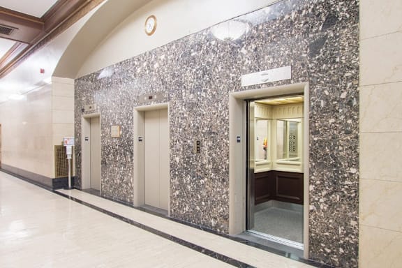 A hallway with a marble wall and a white door.