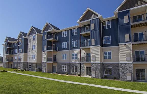 an exterior view of an apartment building with a sidewalk