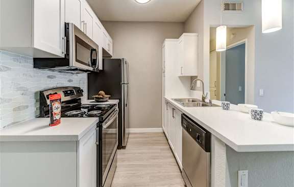 A modern kitchen with a white island and stainless steel appliances.