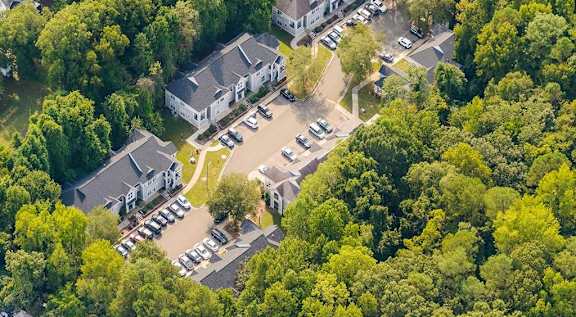 A bird's eye view of a residential area with houses and parked cars.
