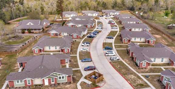 A suburban neighborhood with houses and cars parked in the driveways.