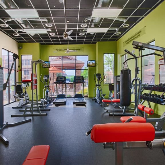 a gym with weights and other equipment in a building with green walls