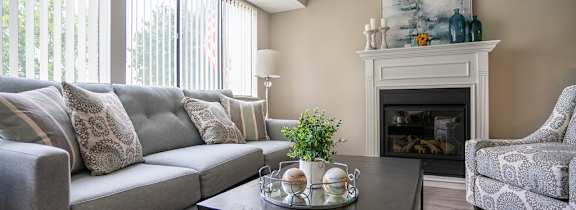 a living room with a couch and a table in front of a fireplace
