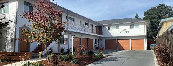 a large white building with a driveway in front of it