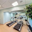 A gym with treadmills, exercise bikes, and weight machines.