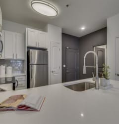 a white kitchen with a sink and a faucet at Flats at West Broad Village in Glen Allen, 23060