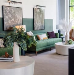 a living room with green couches and a white table at Flats at West Broad Village in Virginia 23060