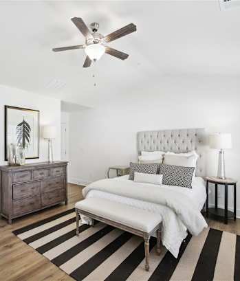 a bedroom with a bed and a ceiling fan