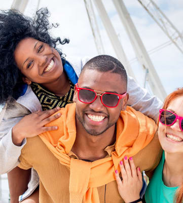 a man and two women wearing sunglasses smile at the camera