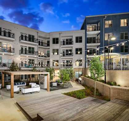 A modern apartment complex with a central courtyard and wooden deck.