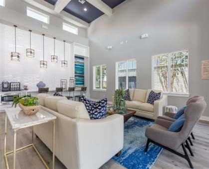 Living room with couches and chairs and a table at Delray Apartments, Houston, Texas