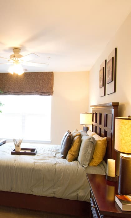 a bedroom with a bed and a dresser and a ceiling fan at The Summit at Owings Mills Apartments, Owings Mills, 21117