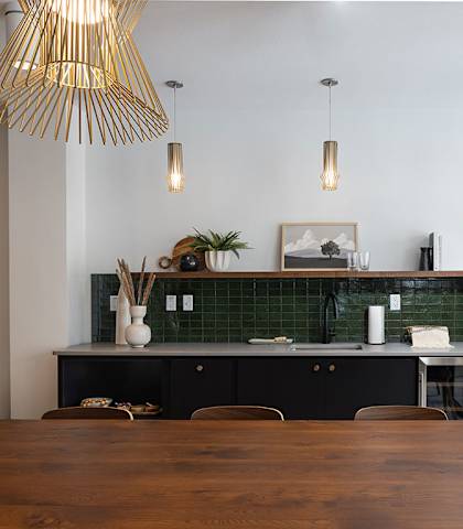 a dining room with a table and chairs and a counter with green tiles  at Kesler Apartments in Downtown Fargo, Fargo, North Dakota, 58102