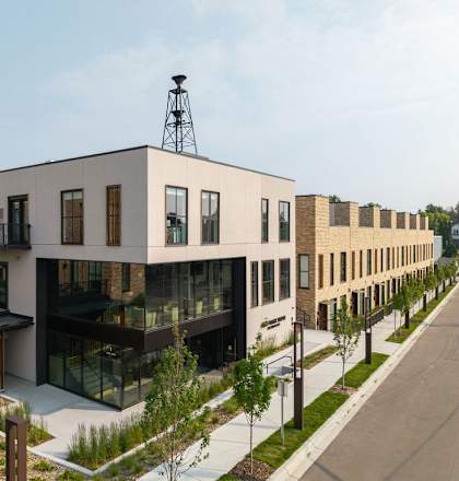 A modern building with a glass facade and a metal structure on top.