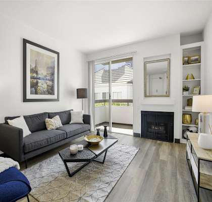 a living room with a couch and a fire place at Enclave, Paramount, CA
