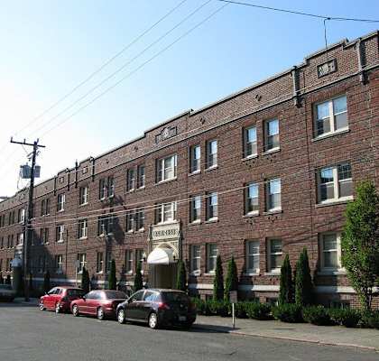 a large brick building with cars parked in front of it at Union Arms, Washington, 98122