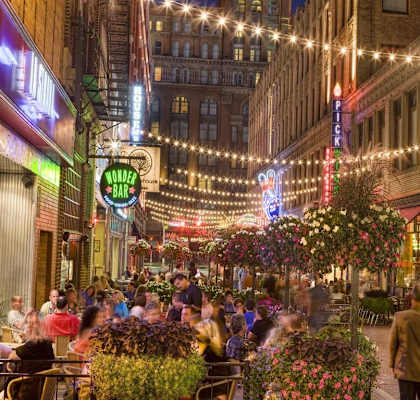 a crowd of people walking down a street at night