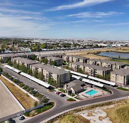 A large apartment complex with a pool and a parking lot.