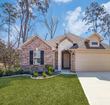 a house with a lawn and trees in the background