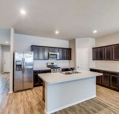 a large kitchen with a large island and stainless steel appliances