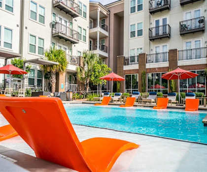 The outdoor pool with pool chairs, tables, and chairs at Parkside at Firewheel Pool. 