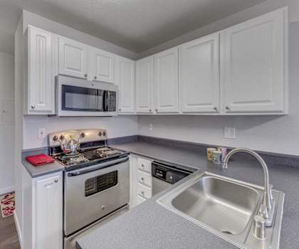 a kitchen with white cabinets and stainless steel appliances