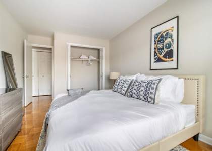 A bedroom with a large bed and a painting on the wall.