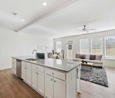 a white living room with a kitchen and a couch