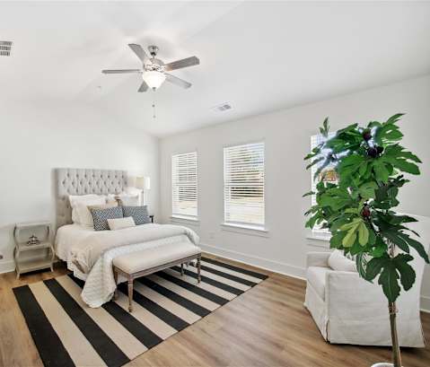 a living room with white furniture and a ceiling fan