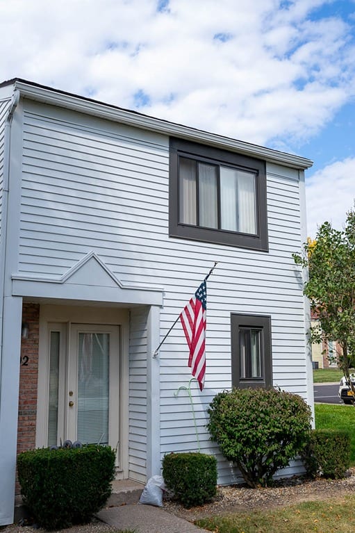 a house on the side of a street with trees