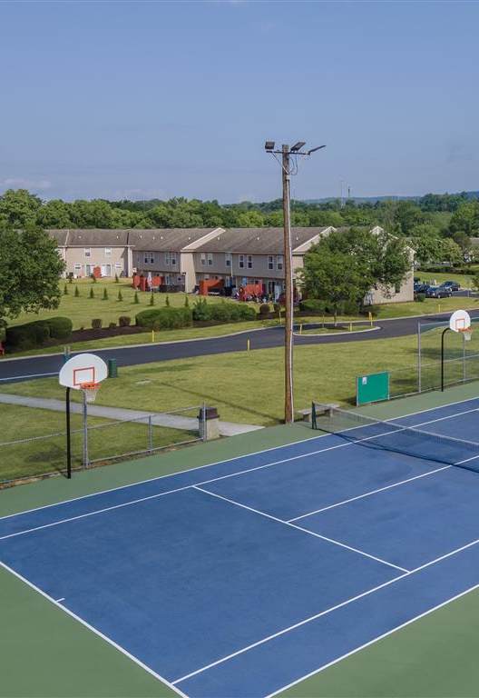 an aerial view of a tennis court with apartments in the background