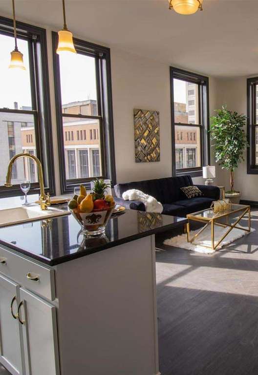 a living room with a kitchen and a large window