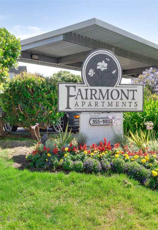 Verdant shrubbery surrounding Fairmont Apartments sign, California
