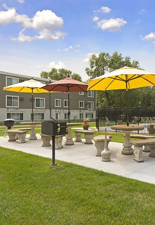 A sunny day at the park with tables and umbrellas. at Minnehaha Manor, Oakdale, MN, 55128