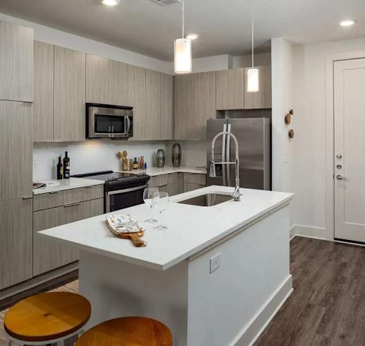 A kitchen with a white island and wooden floors.