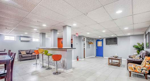 A spacious living room with a kitchen area in the background.