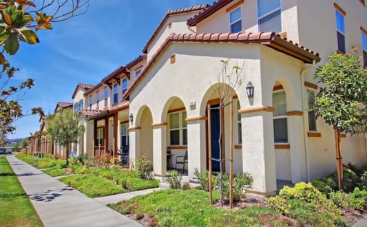 a row of houses with a sidewalk in front of them at The Vines at Riverpark, LLC, Oxnard, 93036
