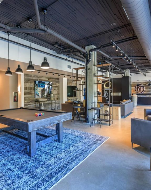 a pool table sits in the middle of a room with couches and chairs