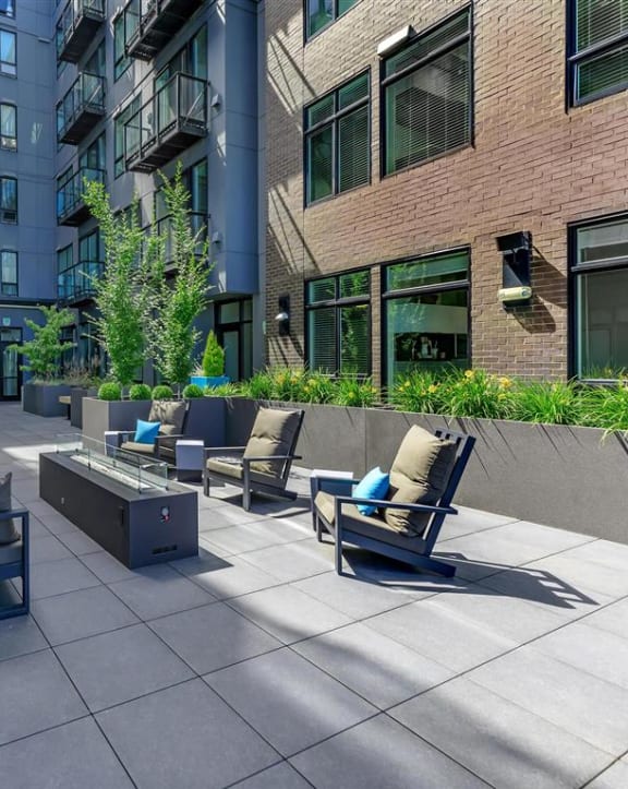 an outdoor patio with a firepit and lounge chairs