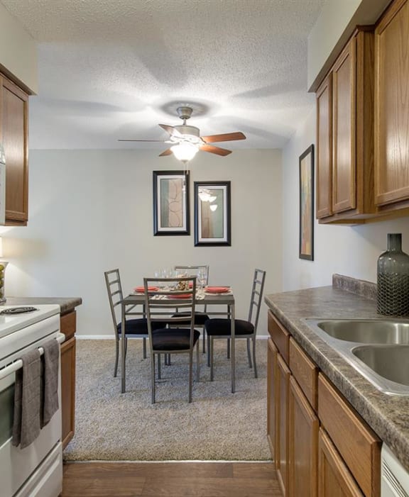 A kitchen with a table and chairs in the middle of the room. at Oakwood, Plymouth, MN, 55447